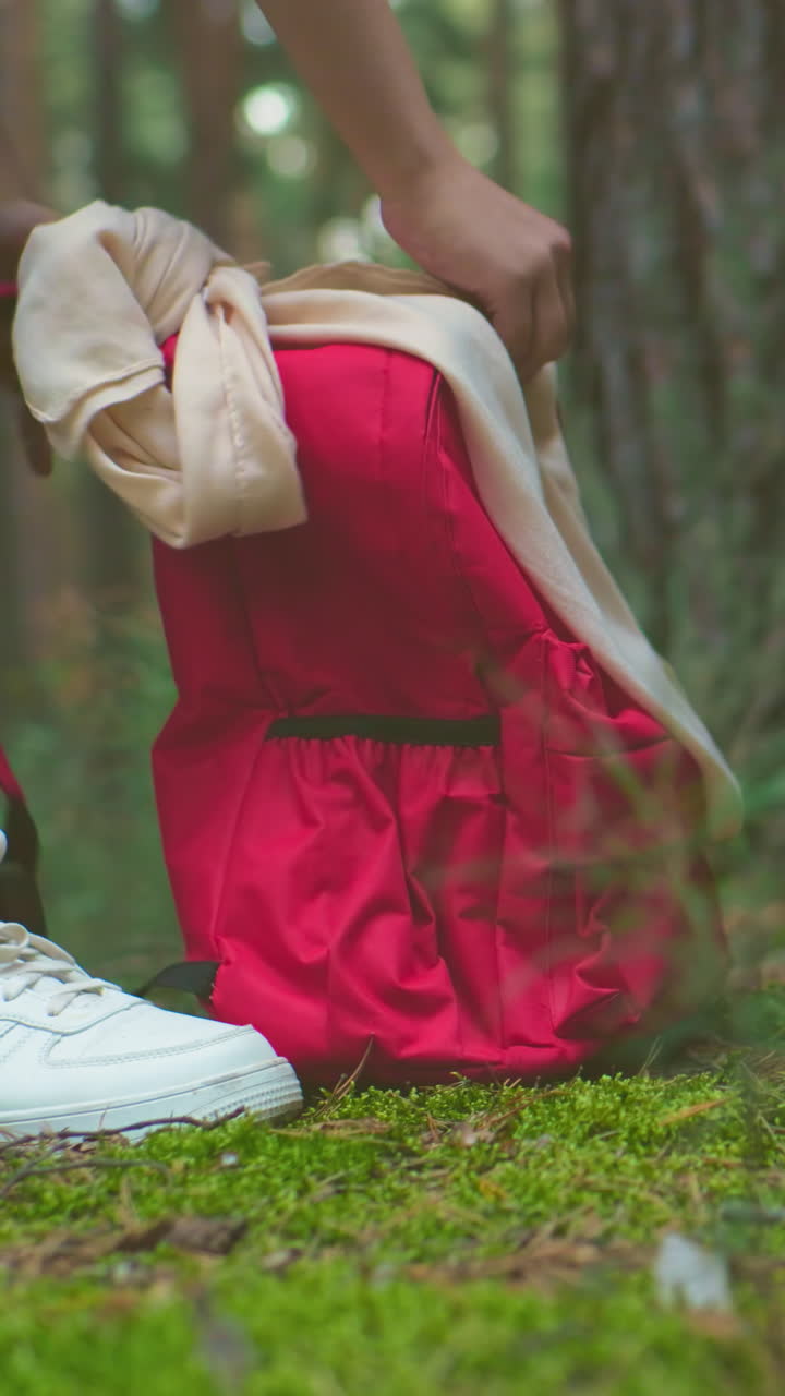 긴 나무와 울창한 초록색으로 둘러싸인 숲에서 가져온 배을 는 청바지와 스니커를 입은 여성들의 클로즈업.