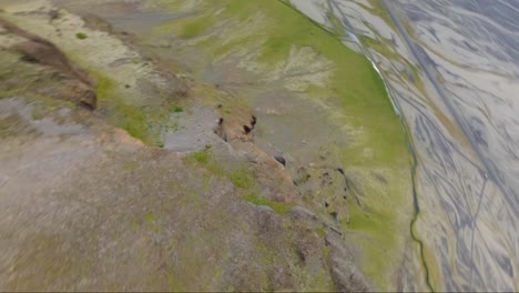 fpv drone dives down a cliff of a steap mountain in iceland like a wingsuit