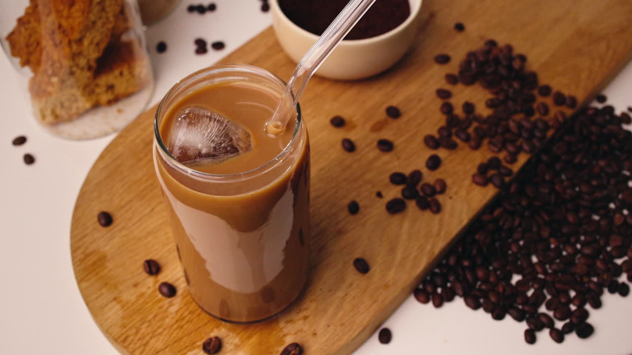 Caffè freddo mescolato con ghiaccio e chicchi di caffè su tavola di legno