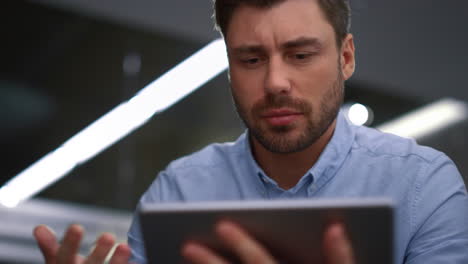 serious entrepreneur talking tablet calling video chat online in company office.