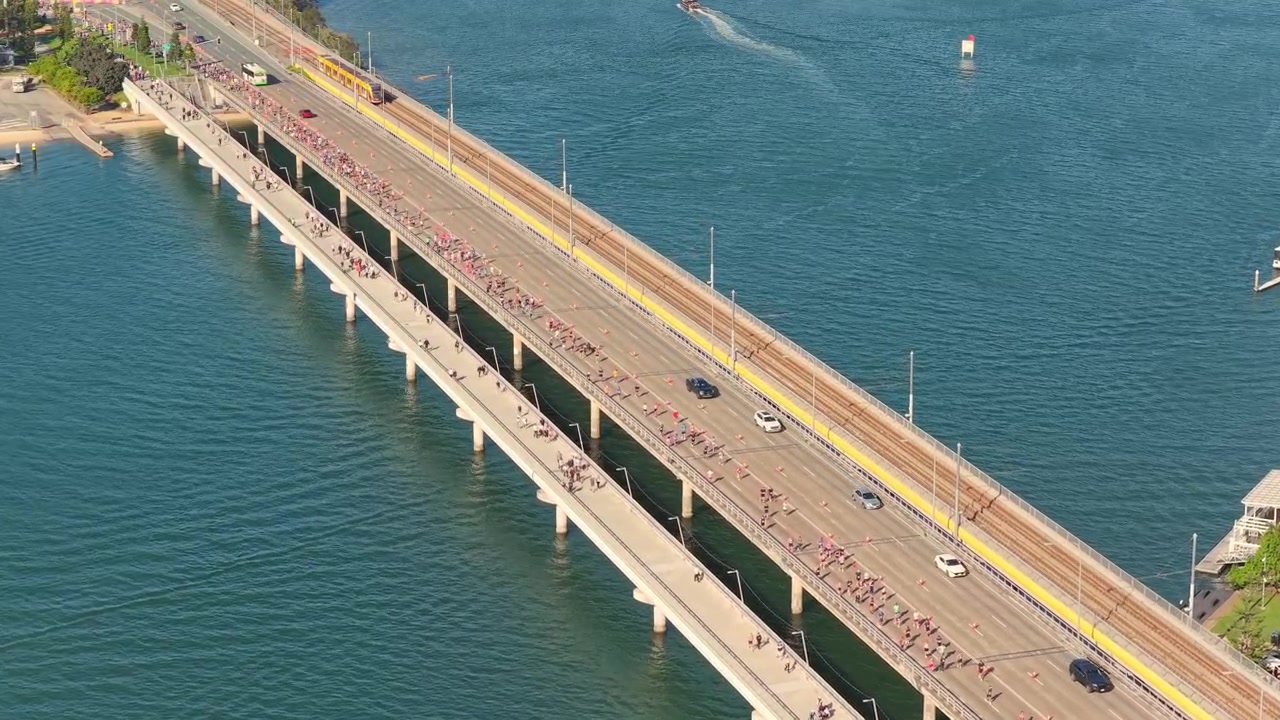 Horisontal luftoptagelse, der bevæger sig fremad over Sundale Bridge under Gold Coast Marathon i Southport, Gold Coast, Queensland, Australien.
