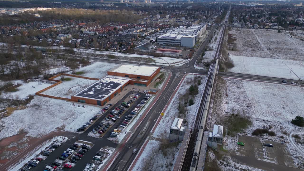 train traveling through a snowy cityscape in segefeld Falkensee. Unique aerial view flight drone shot footage from above