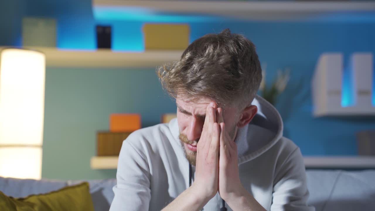 불행과 낮은 도덕성으로 고통받는 젊은 남자는 울고 있습니다.