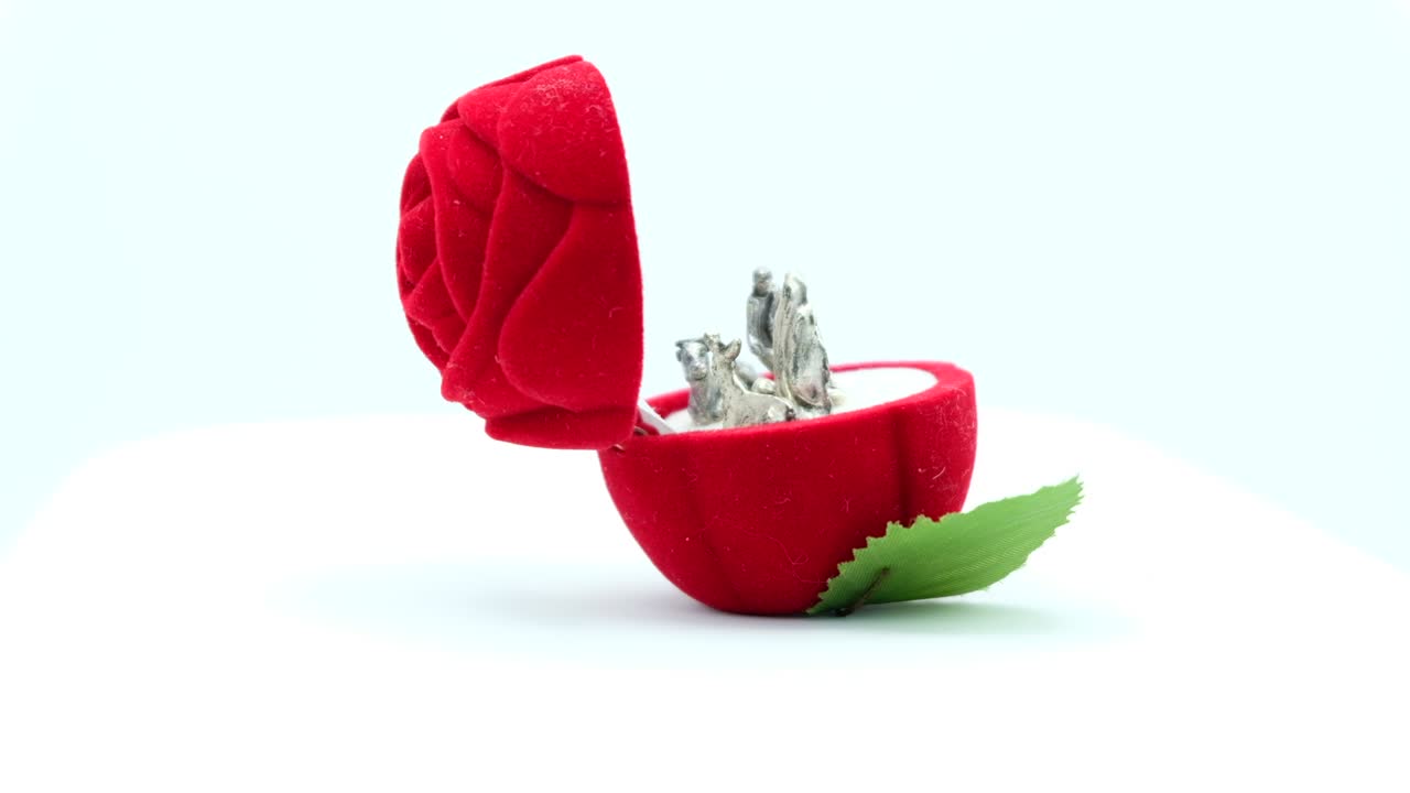 la escena del nacimiento cristiano de plata en una caja de rosas de terciopelo rojo.