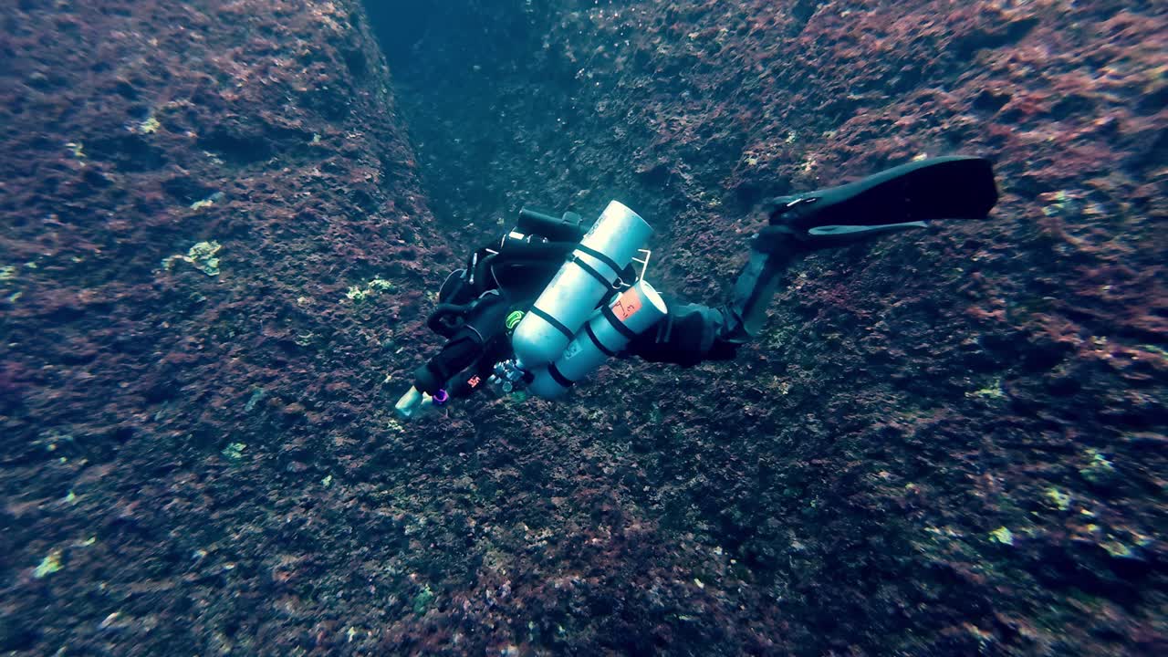Technical Sidemount Diver Navigating Deep Mediterranean Reef Wall in Malta Crystal Clear Blue Waters Professional Scuba Exploration Gozo Underwater Photography High Angle Wide Shot Cinematic Depth