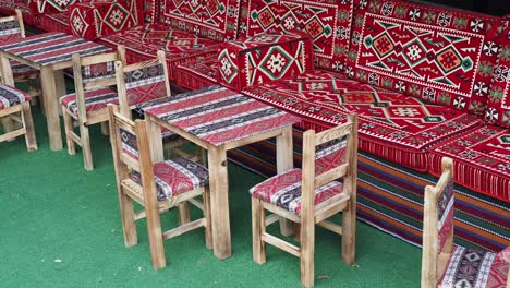 asientos al aire libre con sillas de madera y cojines con patrones rojos