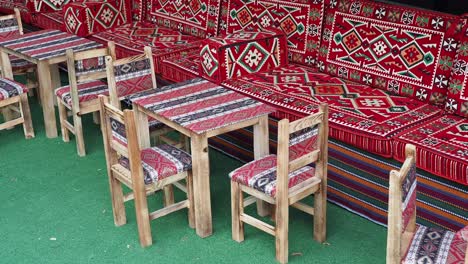 outdoor seating with wooden chairs and red patterned cushions