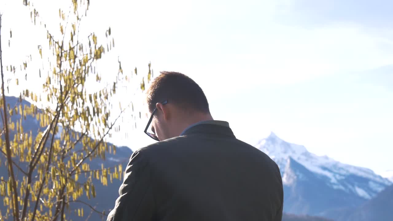 카메라는 마이크를 손에 들고 카메라를 들고 있는 젊은 유럽 남자 주위를 움직입니다.