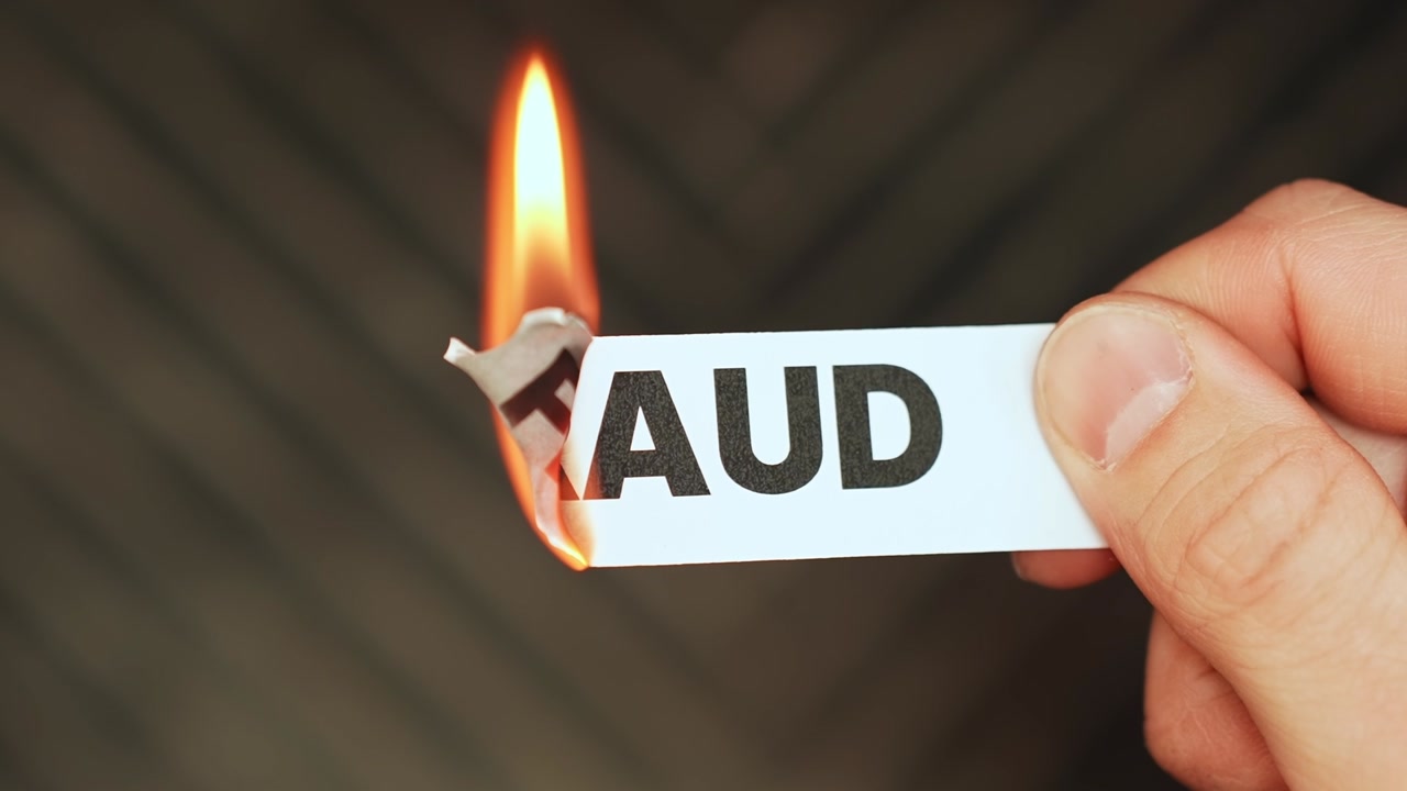Burning “fraud” label held by hand, symbolizing honesty, scam prevention, trust, accountability, and freedom from deception in business or personal life.