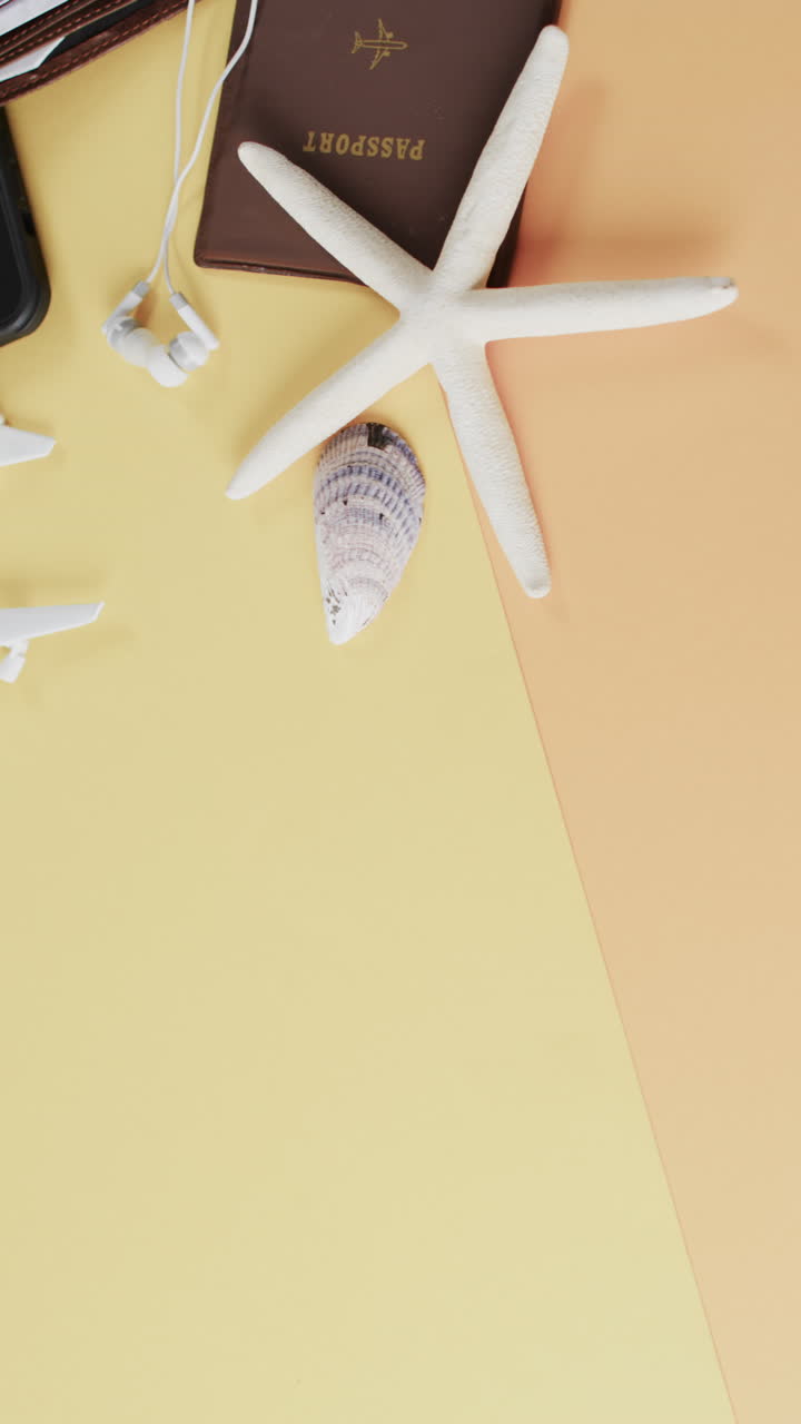 Close up of white airplane model, shells, passport, smartphone and copy space on yellow background