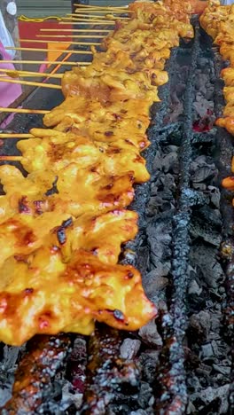 pork skewers being grilled by street vendors