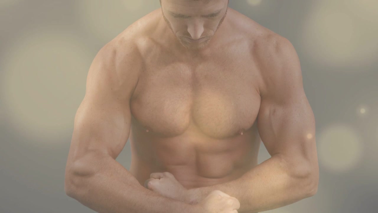 Uomo che inizia con la testa china, la telecamera si allarga, sollevando le braccia e flettendo il petto con un bokeh caldo per il fitness.