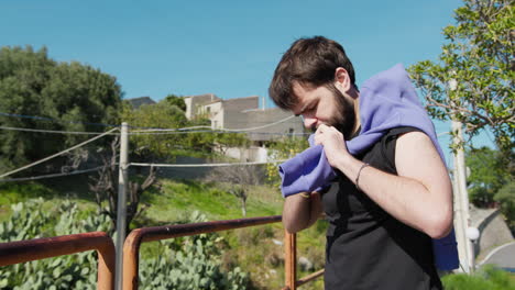 young man in the park ties his sweatshirt around his neck because of the heat