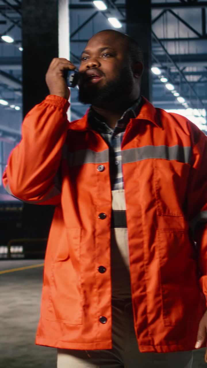 Vertical Video Black operator talks through walkie talkie and monitoring metal fabrication