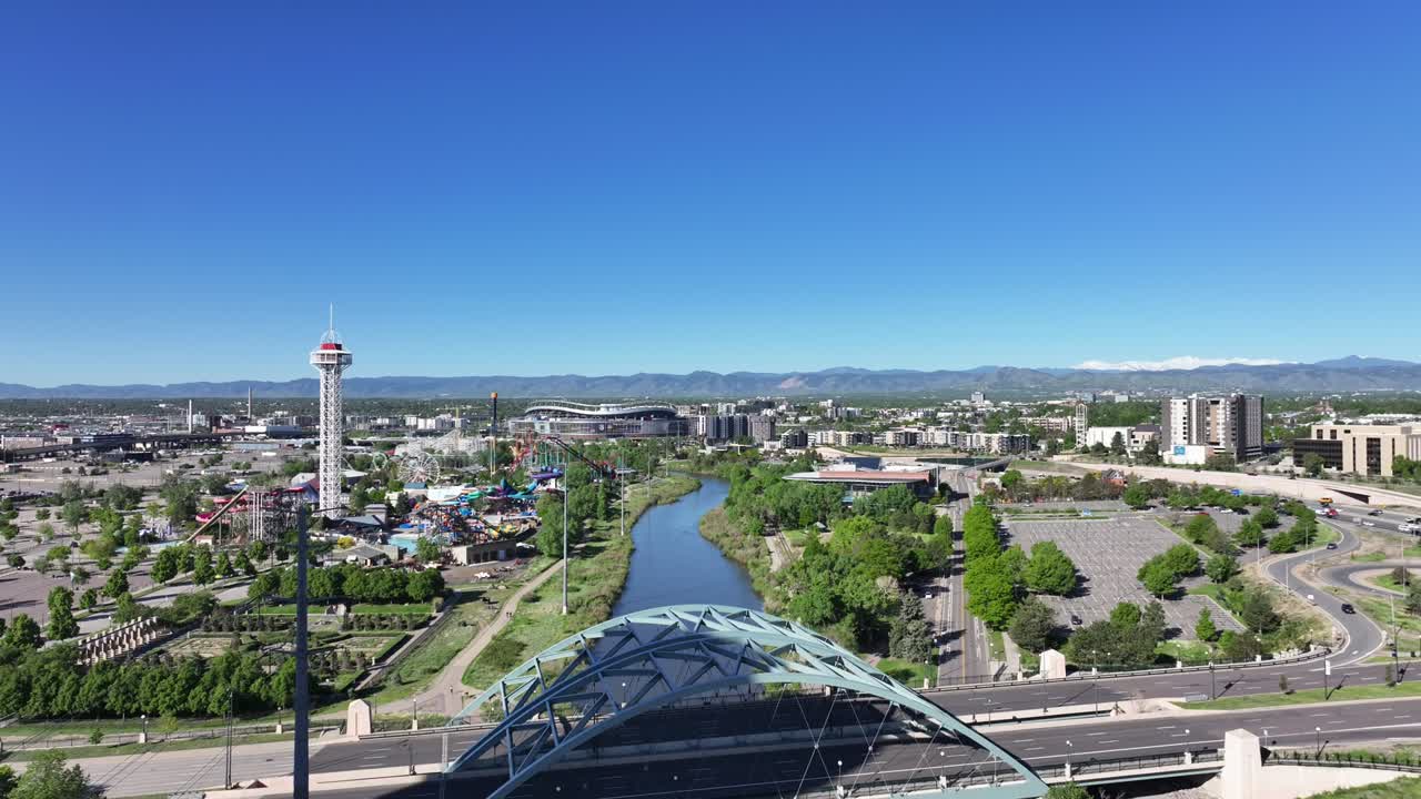 Aerial view of Denver over the South Platte River as the drone flies forward on a clear sunny day