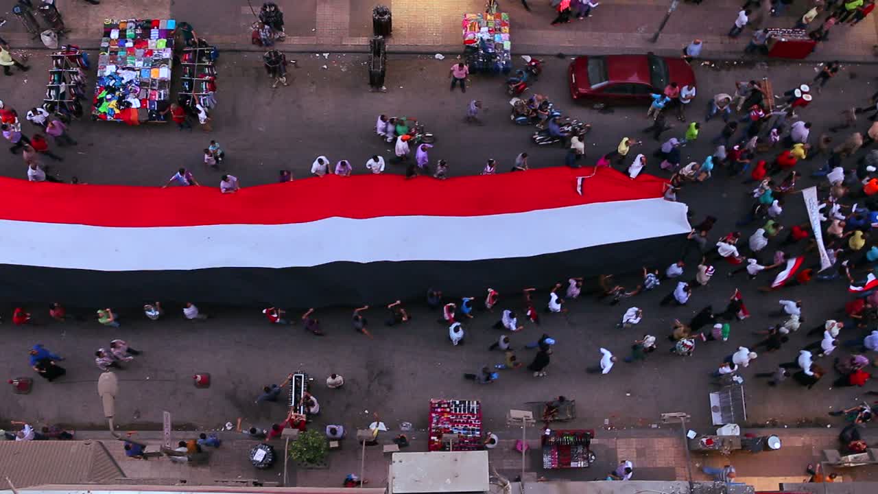 vista desde arriba mirando hacia abajo mientras los manifestantes portan pancartas marchan en las calles de el cairo egipto 2
