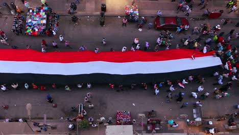 view from overhead looking straight down as protestors carrying banners march in the streets of cairo egypt 2