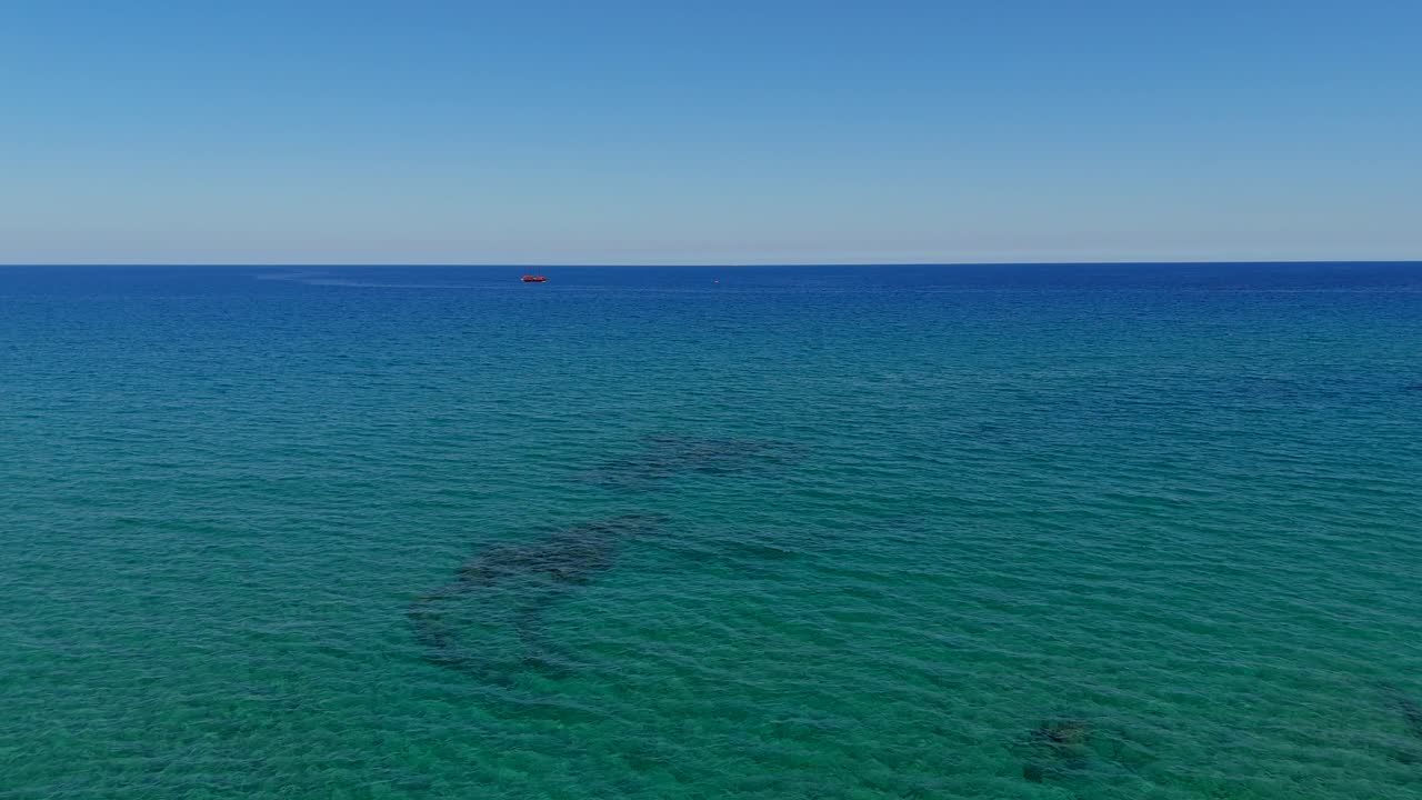 Aerial - fishing boat floating on deep blue open seas near Crete Greece