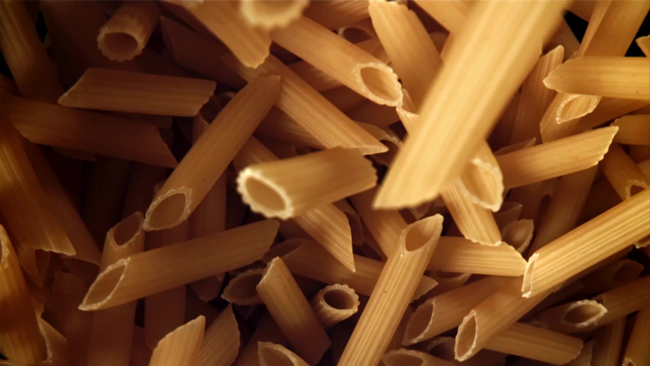Primo piano di penne crude che cadono