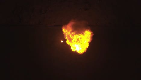 aerial shot young male breathes out large stream of fire making fireball