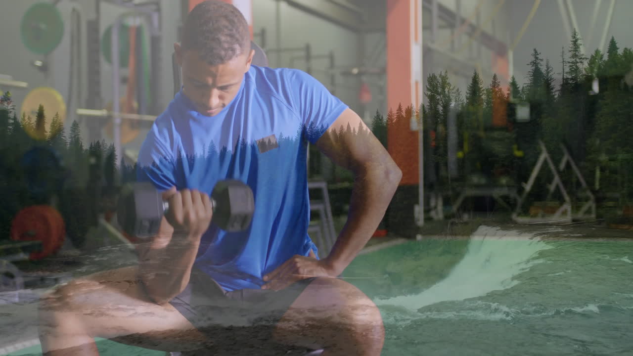 Lifting dumbbell, man in gym with forest and river animation overlay