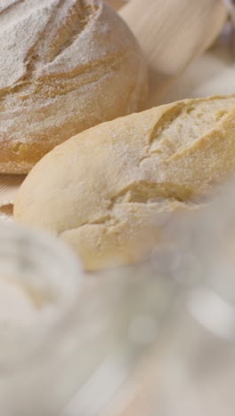 Vertical-Video-Shot-Of-Freshly-Baked-Loaves-Of-Bread-On-Work-Surface