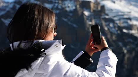 Turista-Femenina-En-Suiza-Sostenga-El-Teléfono-Y-Tome-Fotografías-Del-Paisaje-Natural