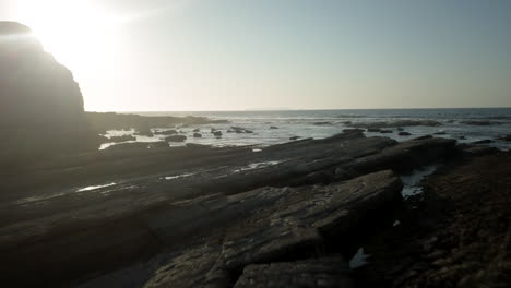 AERIAL---Ocean-flyby-close-to-the-rocks-with-the-sun-as-backlight