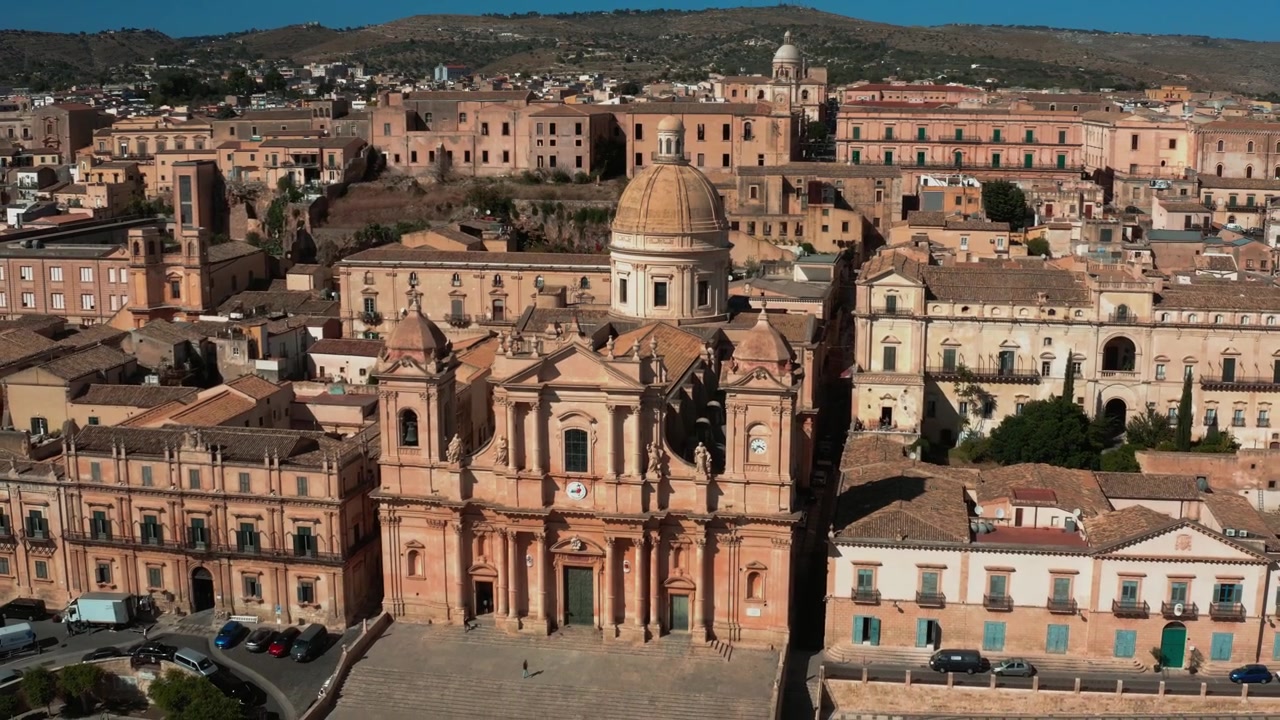 La cámara se aleja lentamente de la ornamentada fachada barroca frontal de la Catedral de Noto, Sicilia.