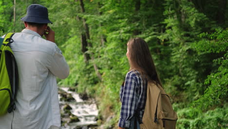 couple hiking in the forest by a mountain stream