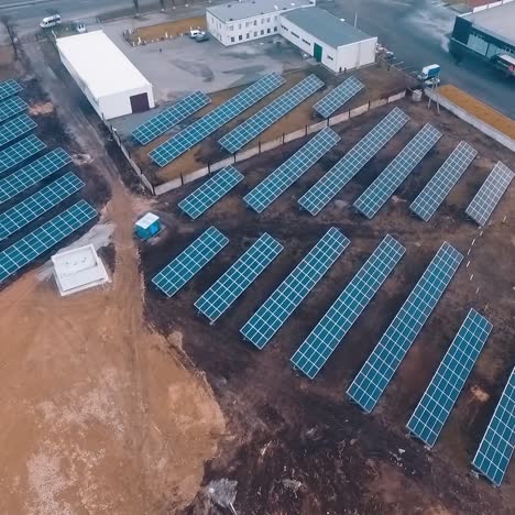 solar power farm in the countryside. blue sunny batteries on brown field. photovoltaic system near the highway. top aerial view.