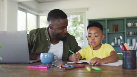 Afroamerikanischer-Vater-Und-Sohn-Machen-Hausaufgaben-Und-Benutzen-Gemeinsam-Einen-Laptop