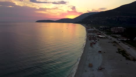 Puesta-De-Sol-En-La-Playa-En-Albania,-Con-La-Puesta-De-Sol-Detrás-De-La-Montaña