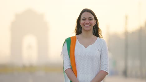 Happy-Indian-woman-standing-in-Indian-traditional-outfit-at-India-gate,-celebrating-Republic-day