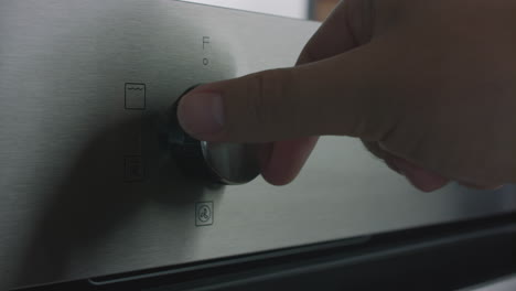 male hand scrolling through the functions on a stainless steel over