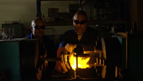 dos trabajadores masculinos que crean vidrio en una fábrica de vidrio 4k