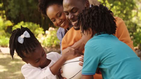 Close-up-of-cute-family-is-playing-rugby-in-a-park-