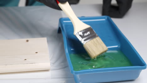 painting a wooden board with green paint