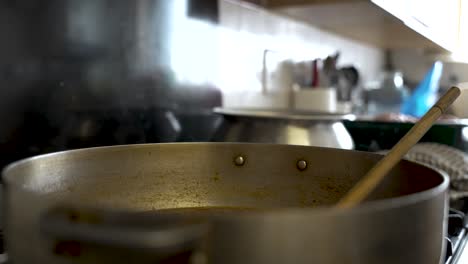 Close-up-shot-of-curry-sauce-prepared-with-onions-in-a-stock-pot-been-cooked-in-a-kitchen