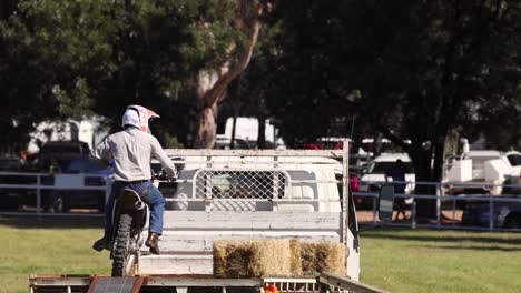 motorcyclist executes stunts over obstacles at event.