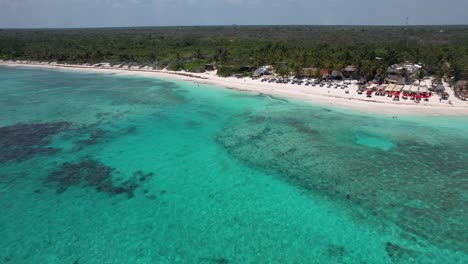 Boats-anchored-off-tropical-beach-with-clear-blue-water-on-Caribbean-ocean