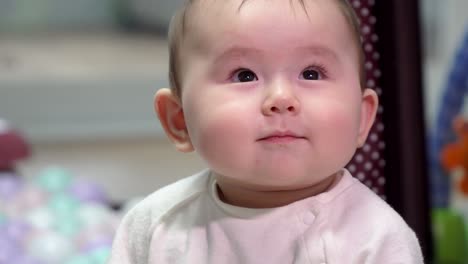 Portrait-shot-of-cute-Asian-baby-showing-small-smirk-as-facial-expression