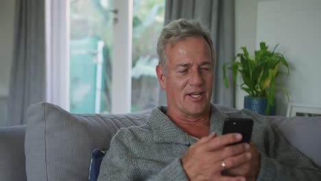 Happy-caucasian-senior-man-using-smartphone-at-home