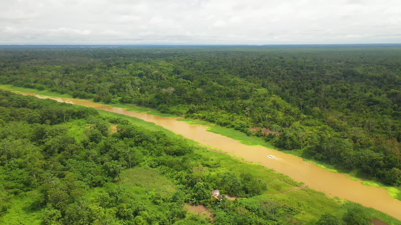 gran tiro giratorio de drones del río amazonas con un pequeño bote bajando por el río con la selva amazónica rodeando por todos lados en perú