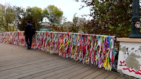 Turista-Paseando-Junto-Al-Ponte-Laços-De-Amizade-De-Madera-Con-Coloridas-Pancartas-Meciéndose-Con-La-Brisa