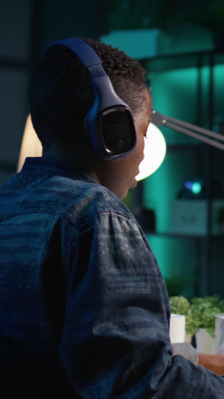 Vertical video Video editor adds sound effects to filmed footage, wearing headphones