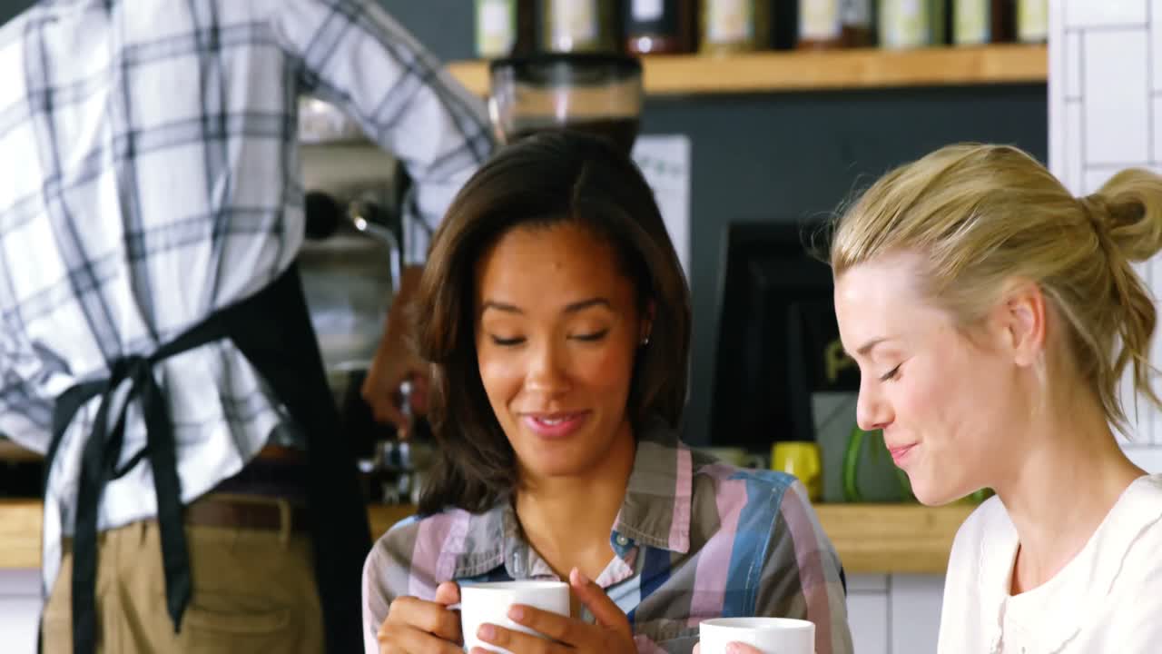 Women interacting with each other while having coffee