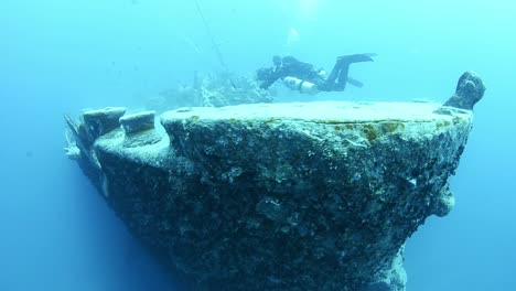 two scuba divers exploring the ss thistlegorm using side mount tanks