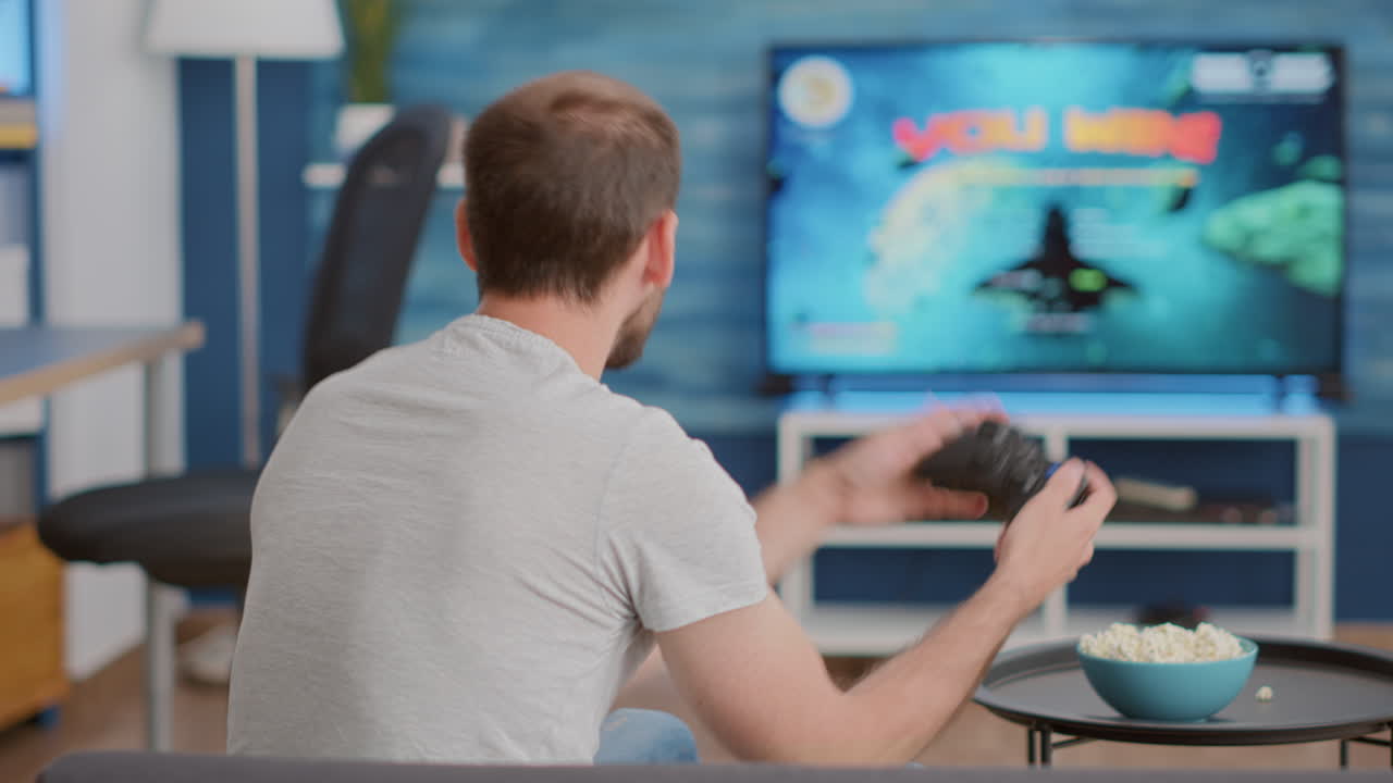 Closeup of man holding controller celebrating victory in online first person shooter game