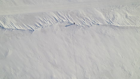 flying drone above a man skiing alone on a frozen lake in canada